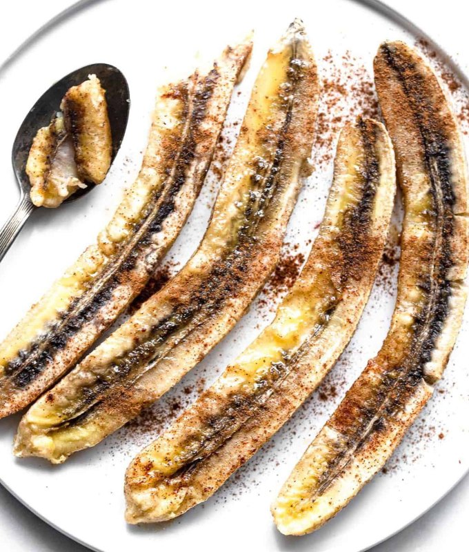 easy snack ideas: baked bananas on a plate with cinnamon and a spoon